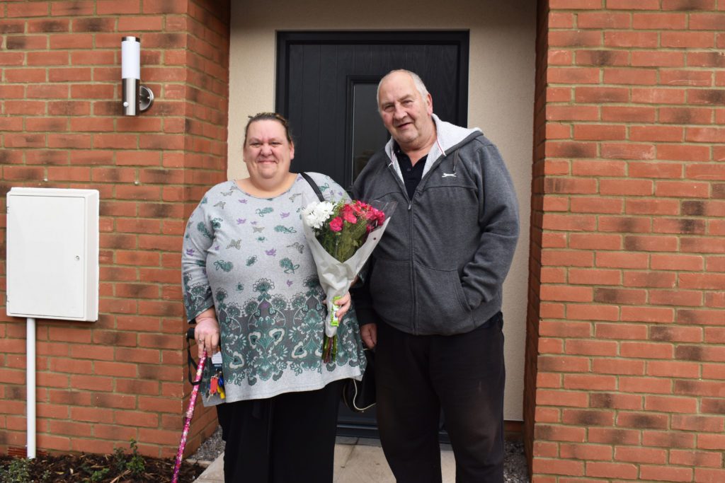 Tenants smiling outside new home