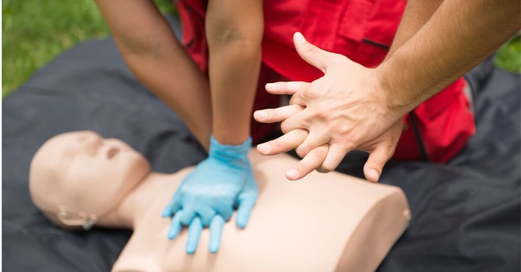close up of hands performing CPR on a mannequin