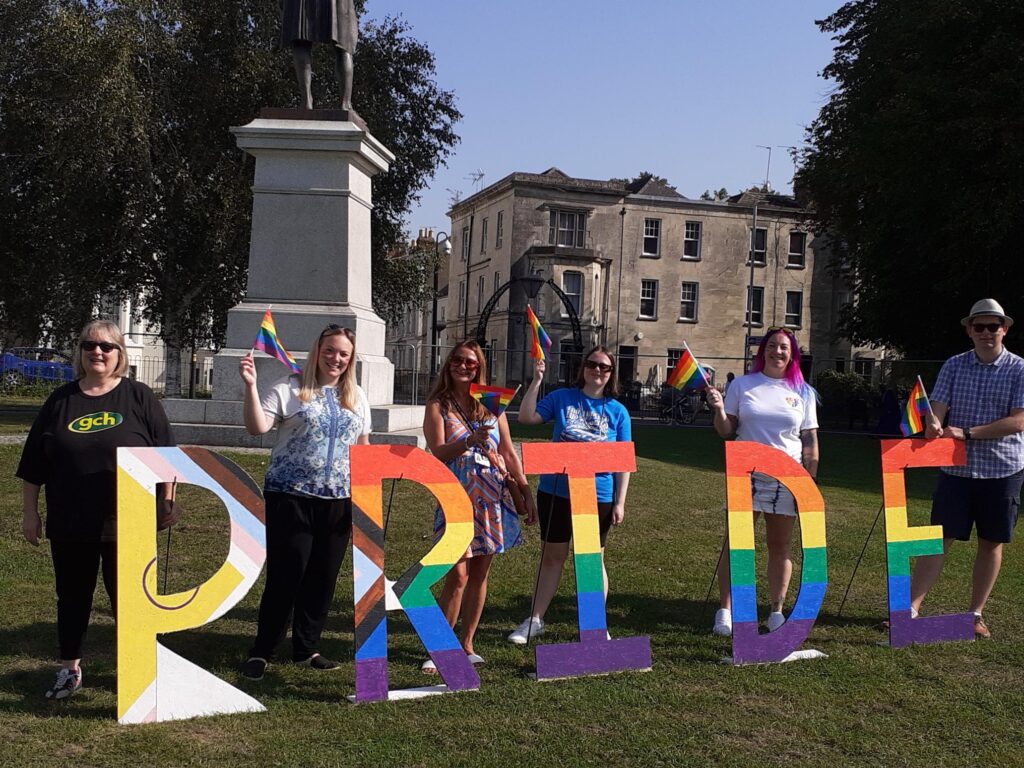 5 GCH colleagues in front of the PRIDE sign at Gloucester Pride event 2023