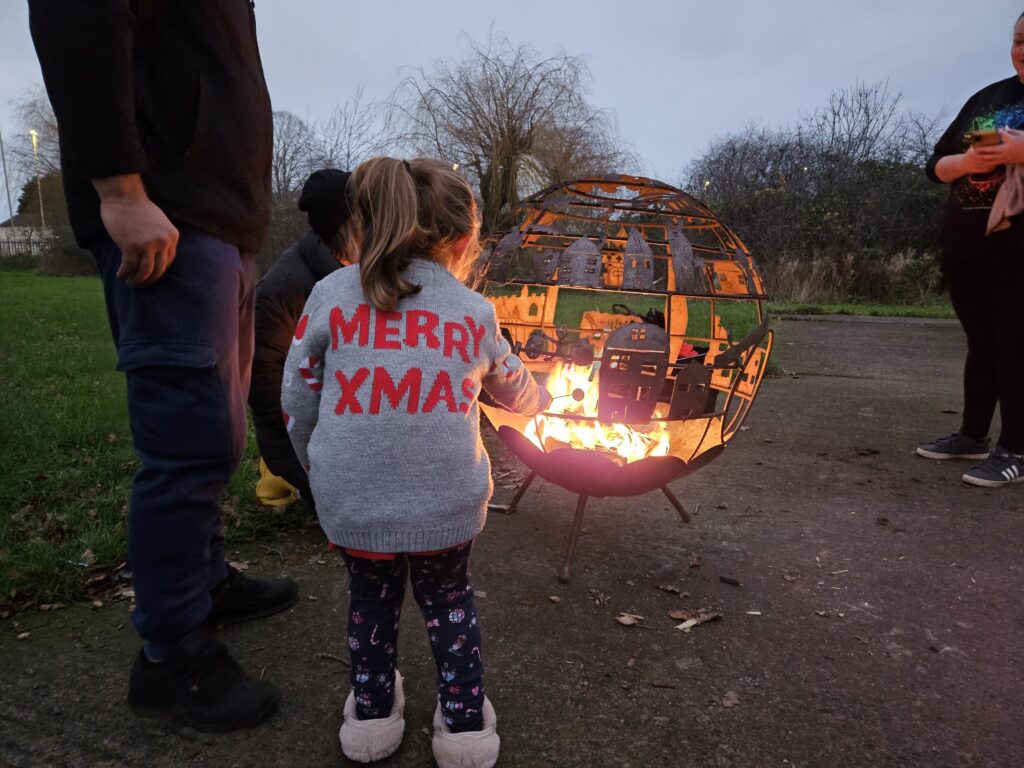 Girl toasting a marshmallow over a fire pit